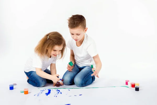 Duas crianças bonitas amigos menino e menina estão desenhando imagens por tintas — Fotografia de Stock