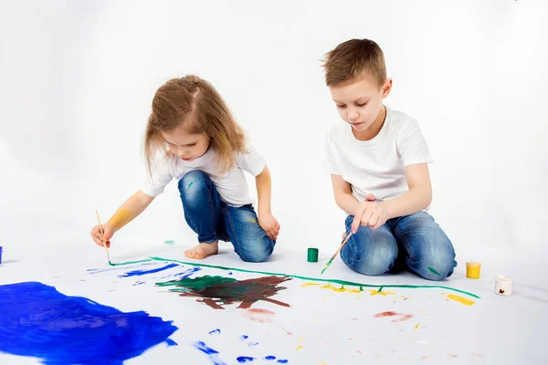 Duas crianças bonitas amigos menino e menina estão desenhando imagens por tintas — Fotografia de Stock