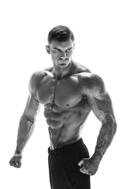 Kaslı süper yüksek seviye yakışıklı bir adam beyaz arka grubunda poz veriyor.