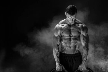Onun kollarında dumbbells ile vücut geliştirmeci