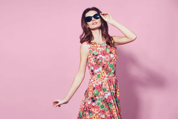 Menina em vestido floral posiciona emocionalmente no fundo laranja — Fotografia de Stock