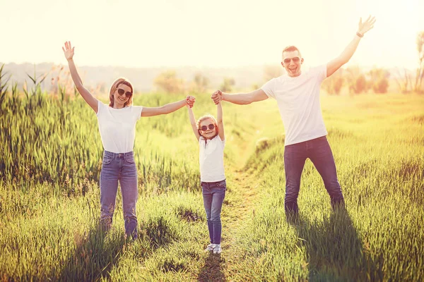Foto Uma família feliz em camisetas brancas, óculos de sol e jeans no parque. Verão — Fotografia de Stock
