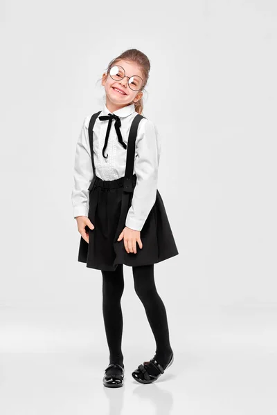 Longitud completa vista del tamaño del cuerpo de agradable atractivo encantadora chica de la escuela tímida en uniforme, gafas redondeadas. Aislado sobre fondo gris — Foto de Stock