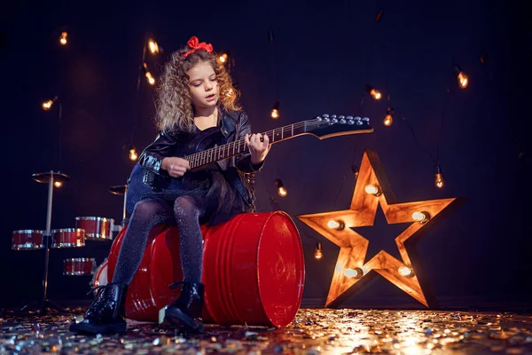 Young attractive rock girl playing the electric guitar