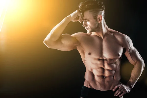 Starker athletischer, muskulöser Mann auf schwarzem Hintergrund — Stockfoto