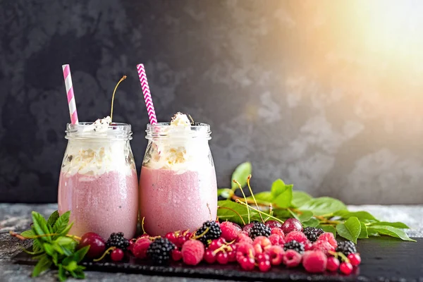 Tejes turmixokat bogyókkal üvegedények — Stock Fotó