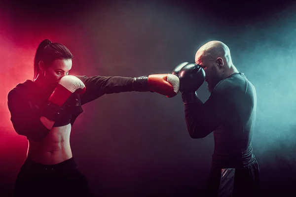 Mulher se exercitando com treinador em boxe e lição de autodefesa — Fotografia de Stock