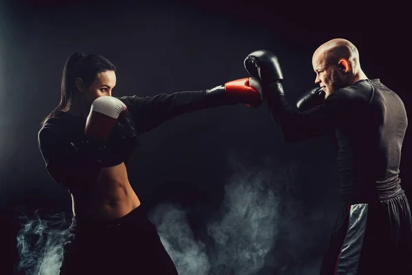 Mulher se exercitando com treinador em boxe e lição de autodefesa — Fotografia de Stock