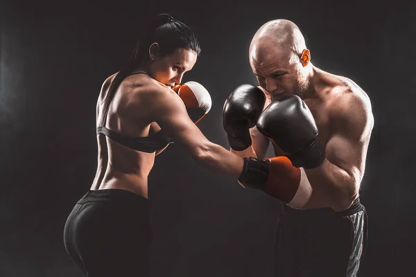 Póló nélküli nő edz edzővel a boksz és önvédelmi órán, stúdió, füst a háttérben. Női és férfi harc — Stock Fotó