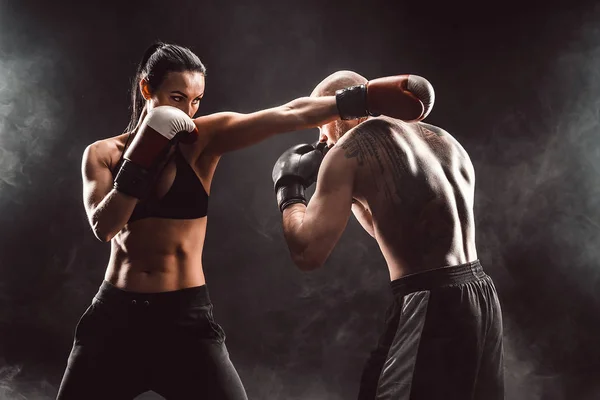 Женщина тренируется с тренером на уроке бокса и самообороны — стоковое фото