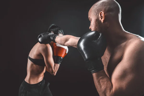 Shirtless Woman exercising with trainer at boxing and self defense lesson, studio, smoke on background. Female and male fight — Stock Photo, Image