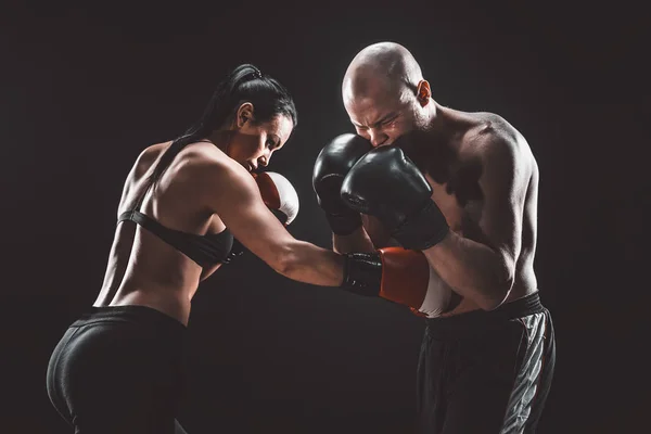 Mujer sin camisa haciendo ejercicio con entrenador en el boxeo y autodefensa lección, estudio, humo de fondo. Lucha femenina y masculina — Foto de Stock