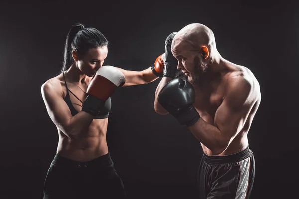 Женщина без рубашки упражнения с тренером на уроке бокса и самообороны, студия, дым на заднем плане. Женская и мужская борьба — стоковое фото