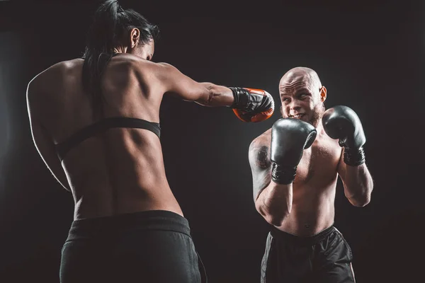Shirtless Woman traint met trainer bij boks- en zelfverdedigingsles, studio, rook op de achtergrond. Vrouwelijke en mannelijke strijd — Stockfoto
