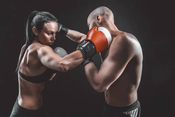 Shirtless Woman exercitando-se com o treinador na aula de boxe e autodefesa, estúdio, fumaça no fundo. Feminino e masculino luta — Fotografia de Stock