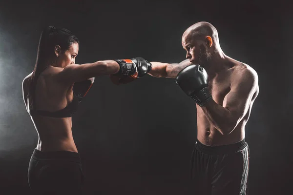 Shirtless Woman exercice avec entraîneur à la boxe et leçon d'autodéfense, studio, fumée en arrière-plan. Combat féminin et masculin — Photo