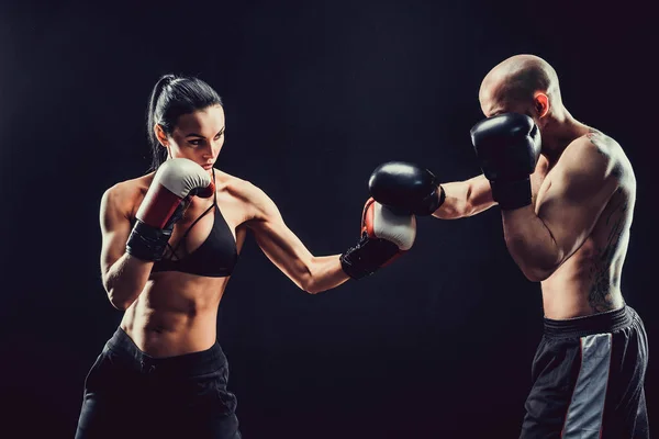 Shirtless Woman exercitando-se com o treinador na aula de boxe e autodefesa, estúdio, fumaça no fundo. Feminino e masculino luta — Fotografia de Stock