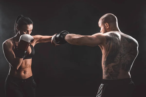 Shirtless Woman exercitando-se com o treinador na aula de boxe e autodefesa, estúdio, fumaça no fundo. Feminino e masculino luta — Fotografia de Stock