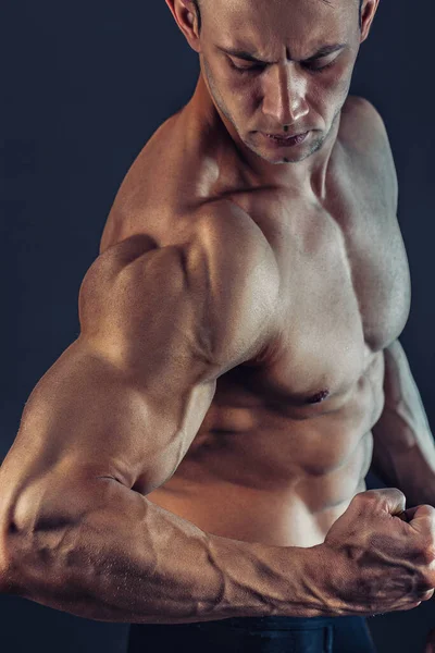 Shirtloze mannelijke bodybuilder met spieropbouw sterke buikspieren laten zien. Een schot gezonde gespierde jongeman. Perfecte pasvorm, six pack, buikspieren, schouders, deltaspier, biceps, triceps en borst — Stockfoto