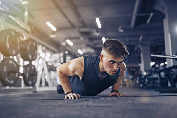 Atleta adulto joven que hace los aumentos de presión como parte del entrenamiento del levantamiento de pesas — Foto de Stock