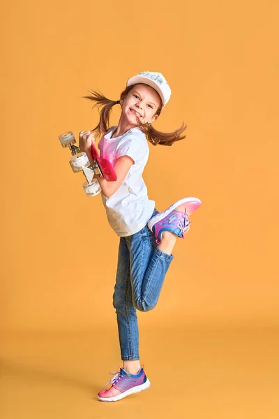 Activo y feliz. El chico se divierte con Penny Board. Niño sonriente cara pie monopatín. Penny board monopatín lindo para las niñas. Vamos a montar. Chica paseo penny board fondo blanco. Vacaciones de verano — Foto de Stock