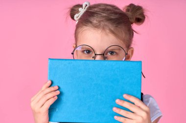 Onun güzel seksi, çekici, neşeli, pozitif okul kızının portresi. El ele tutuşup açık sınav hazırlıklarının arkasına saklanıyor. Pembe arka planda izole edilmiş.