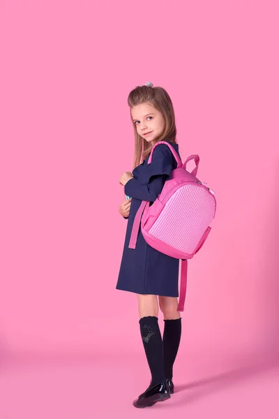 Voltar ao conceito da escola Meia foto virou retrato de linda menina inteligente confiante bonita com caderno copybook vestindo vestido uniforme escolar rosa mochila brilhante isolado — Fotografia de Stock