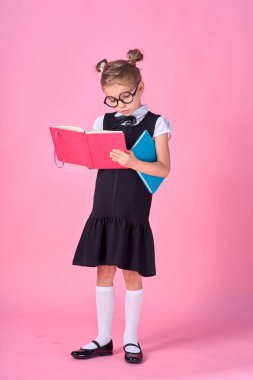 Gözlükleri ve pembe arka plan kitapları olan sevimli küçük bir kız. Mesaj atmak için yer var. Okuma konsepti