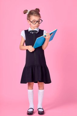 Gözlükleri ve pembe arka plan kitapları olan sevimli küçük bir kız. Mesaj atmak için yer var. Okuma konsepti