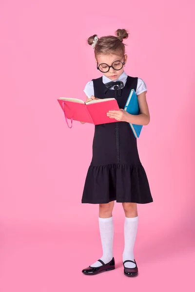 Jolie petite fille avec des lunettes et des livres sur fond rose, espace pour le texte. Concept de lecture — Photo