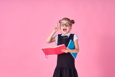 Pembe arka plandaki bir şeyi işaret eden duygusal tahmini olan bir kız öğrencinin resmi.