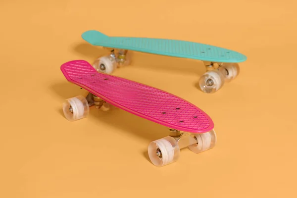 Twee penny skateboard roze en groen geïsoleerd op gele achtergrond — Stockfoto