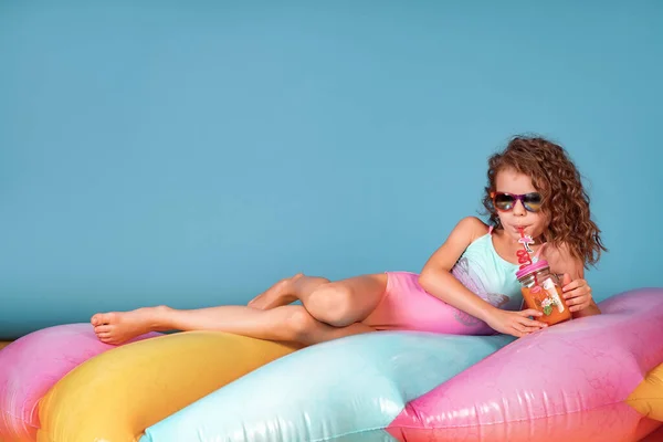 Piękna dziewczyna w kolorowym stroju kąpielowym i okularach przeciwsłonecznych trzymając koktajl ananasowy — Zdjęcie stockowe