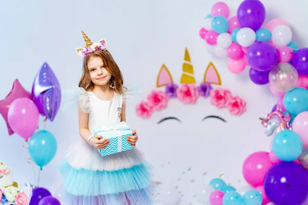Unicórnio menina segurando caixa de presente. Ideia para decorar festa de aniversário estilo unicórnio. Decoração de unicórnio para festa menina — Fotografia de Stock