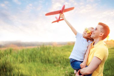 Mutlu baba ve kız uçakla oynuyor.
