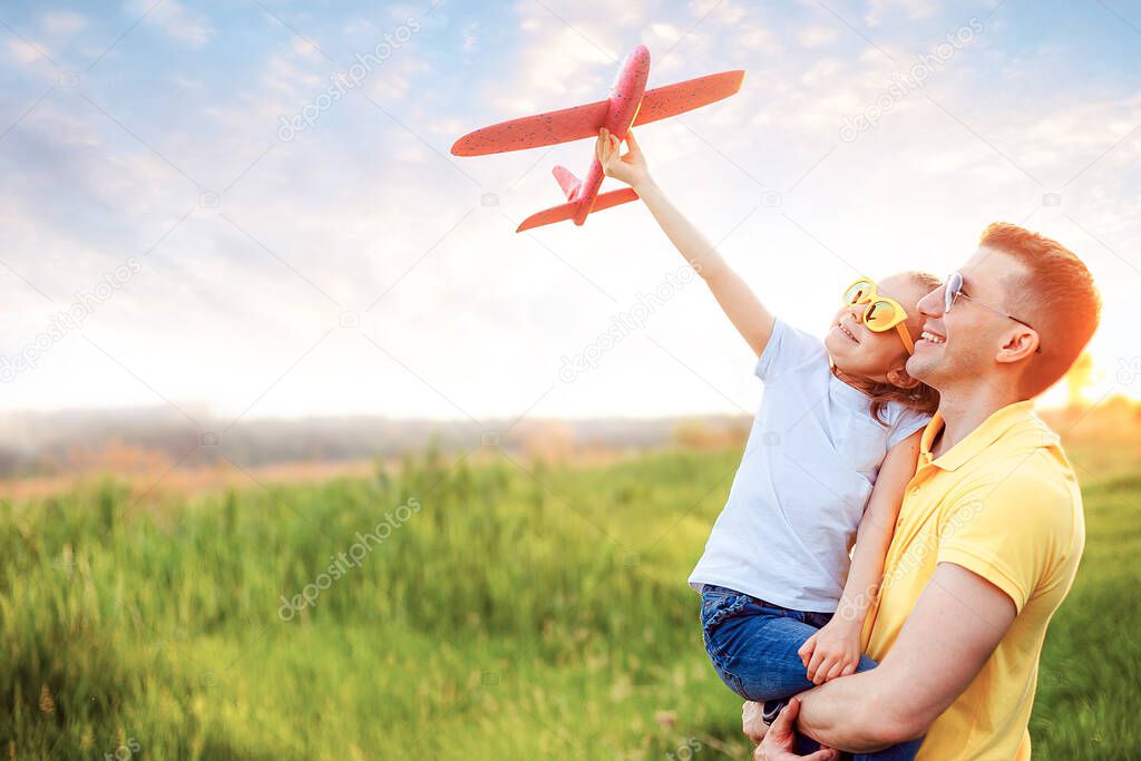 Happy father and daughter playing with plane