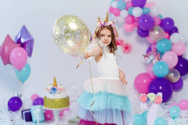 Unikornis lány kezében arany konfetti léggömb. Ötlet a díszítő unikornis stílusú születésnapi party. Egyszarvú dekoráció fesztivál party lány — Stock Fotó