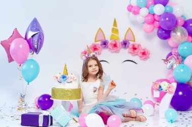 Tekboynuzlu Kız hediye kutusu tutuyor. Tek boynuzlu at stili doğum günü partisi için bir fikir. Festival kızı için tek boynuzlu at süsü