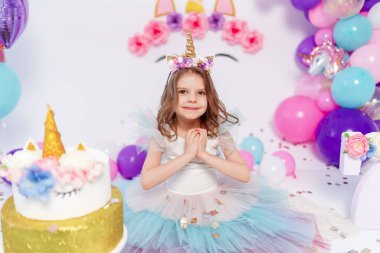 Tek boynuzlu at kız konfeti fırlatıyor. Tek boynuzlu at stili doğum günü partisi için bir fikir. Festival kızı için tek boynuzlu at süsü