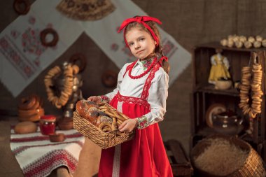 Güzel kız geleneksel evde bir sepet simit ve diğer pastaları tutuyor.