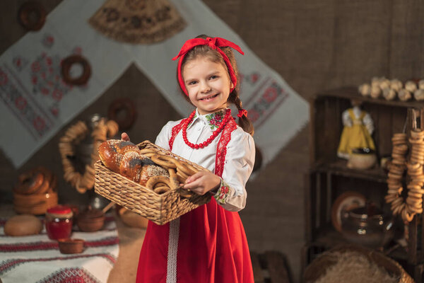 Красивая девушка держит корзину бубликов и других выпечки в традиционном доме
