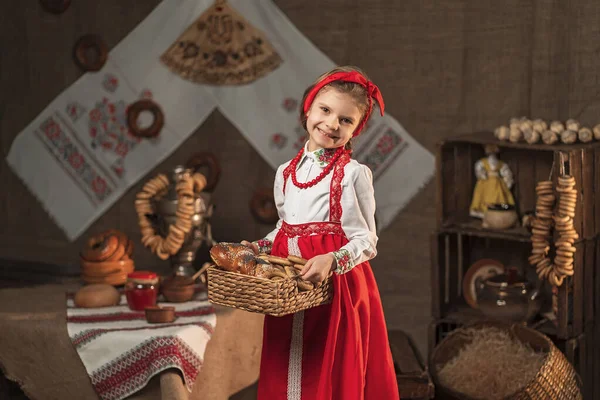 Hübsches Mädchen hält Korb mit Bagels und anderem Backen in traditionellem Haus — Stockfoto