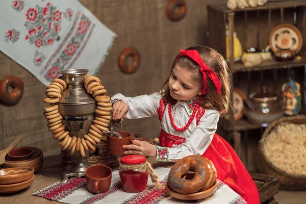 Adorável menina derramando chá de samovar — Fotografia de Stock