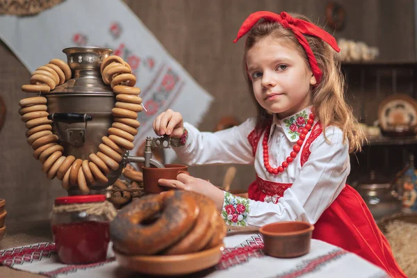 Adorável menina derramando chá de samovar — Fotografia de Stock