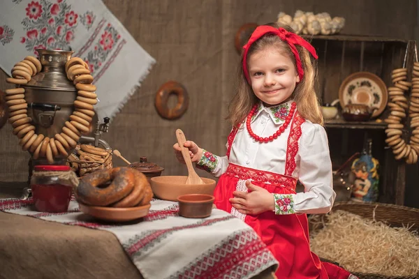 Menina adorável sentada à mesa cheia de comida e grande samovar. Tradicional celebrando Maslenitsa — Fotografia de Stock