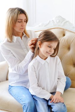 Annem kızının saçını düzeltir. Ebeveynler ve çocuklar. Aile değerleri ve halalar ve ebeveynlerin ilişkileri