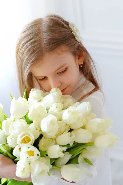 Портрет красивой девушки с белыми цветами тюльпанов. Фото в помещении — стоковое фото