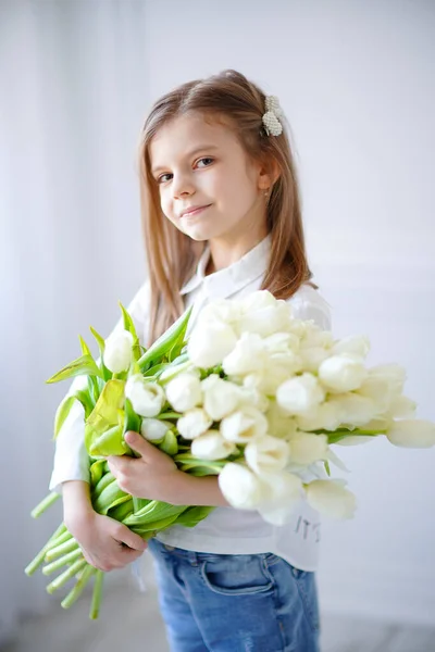 Портрет красивой девушки с белыми цветами тюльпанов. Фото в помещении — стоковое фото