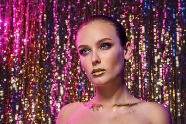 Stüdyoda, gece kulübünde renkli parlak ışıklarla poz veren renkli arkaplanda yüksek moda model bir kadının güzel portresi.