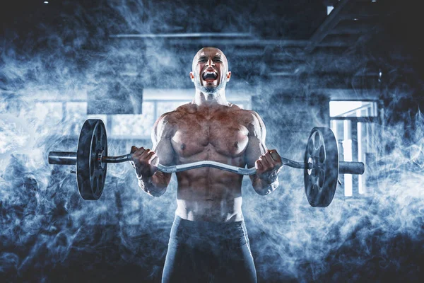 Hombre musculoso ejercitándose en el gimnasio haciendo ejercicios con pesas en bíceps, fuertes abdominales masculinos desnudos del torso — Foto de Stock